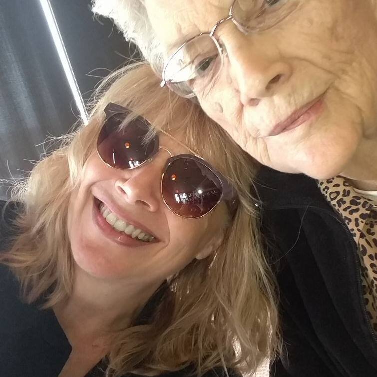 two woman wearing glasses smiling