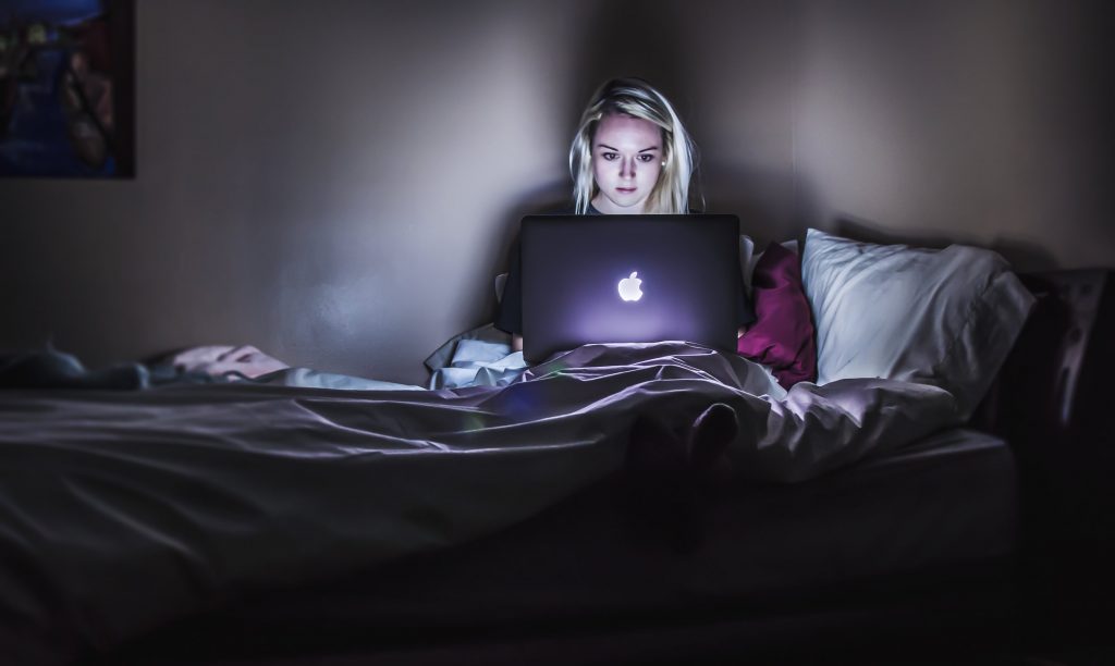 woman using laptop in bed overnight